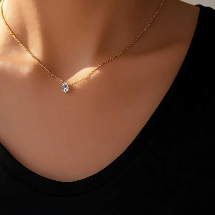 Entdecke die zeitlose Eleganz unserer zarten Halskette mit funkelndem Tropfenanhänger aus hochwertigem Zirkonia. Die feine Goldkette schmiegt sich dezent an dein Dekolleté und setzt mit dem klaren, strahlenden Stein einen stilvollen Akzent. Ob im Alltag, im Büro oder zu besonderen Anlässen – dieses Schmuckstück verleiht jedem Outfit einen Hauch von Luxus und Understatement.
