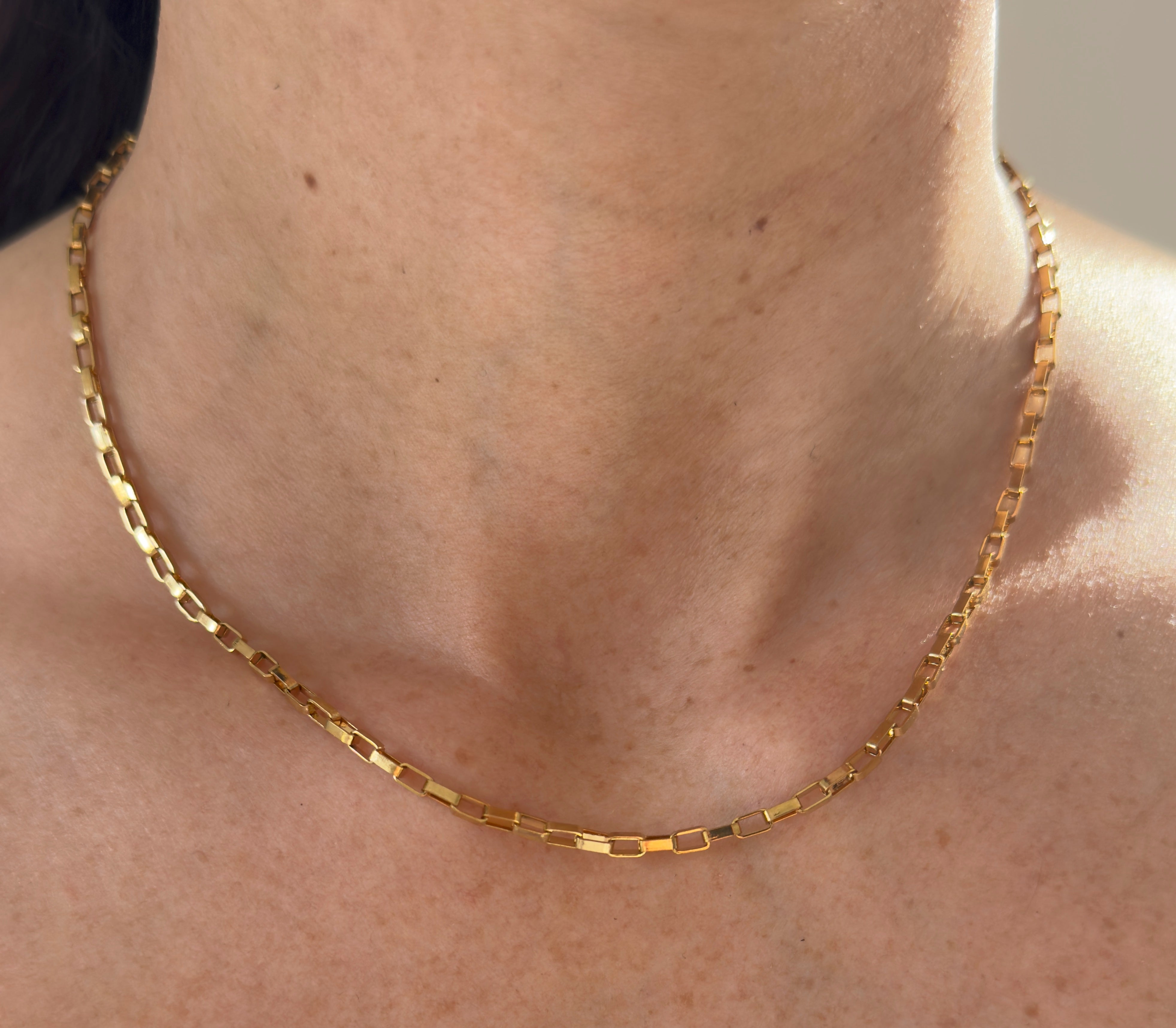 Nahaufnahme Anchor Chain Goldkette aus Edelstahl am Hals, minimalistisch und elegant für Damen und Herren.