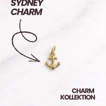 Detailfoto: goldener Anker-Charm auf hellem Hintergrund, nickelfrei und hautfreundlich.