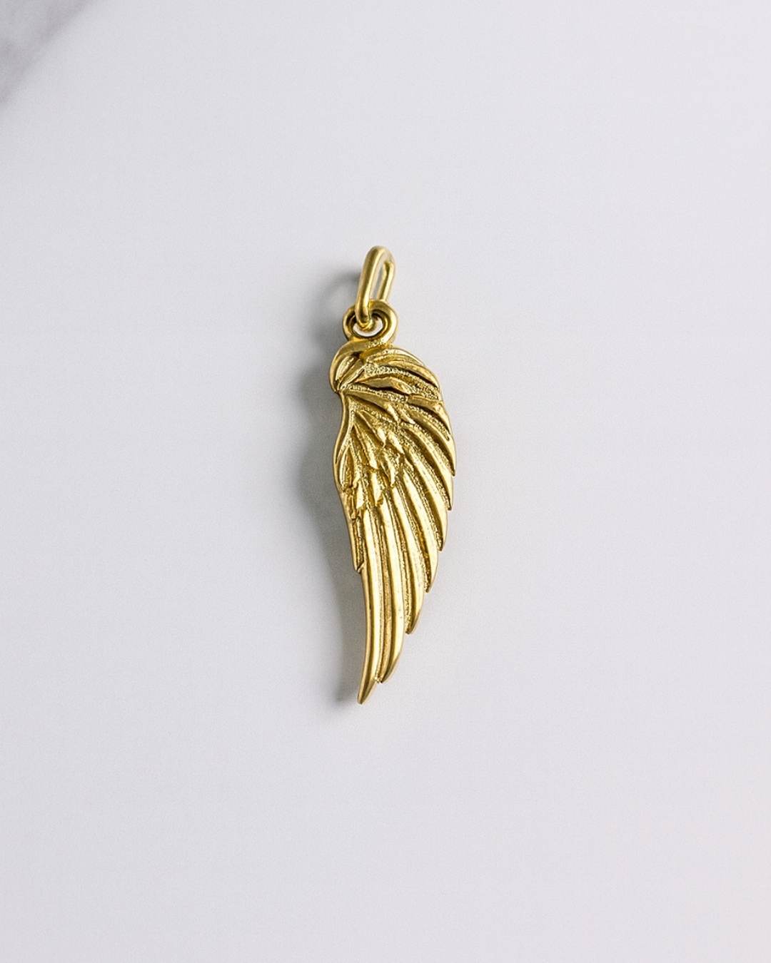 Goldener Athen Charm als filigraner Flügelanhänger auf hellem Hintergrund, geeignet für Ketten und Armbänder