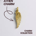 Detailaufnahme eines vergoldeten Flügel Charms der Athen Kollektion auf weißem Hintergrund