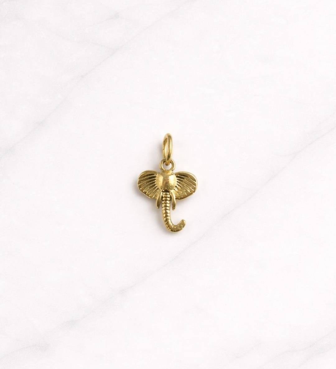 Bangkok CHARM in Gold als filigraner Elefant Anhänger auf hellem Hintergrund.
