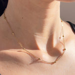 Nahaufnahme Bubble Chain Goldkette mit kleinen Kugeln, 18K vergoldeter Edelstahl an Frauenhals, zarter Damenschmuck.