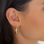 Bump S Creole in Gold am Ohr einer Frau, kleiner eleganter Hoop für den Alltag.