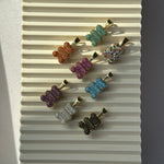 Bunte Glitzer Bärchen Anhänger in Gold mit Zirkonia in vielen Farben auf hellem Hintergrund.