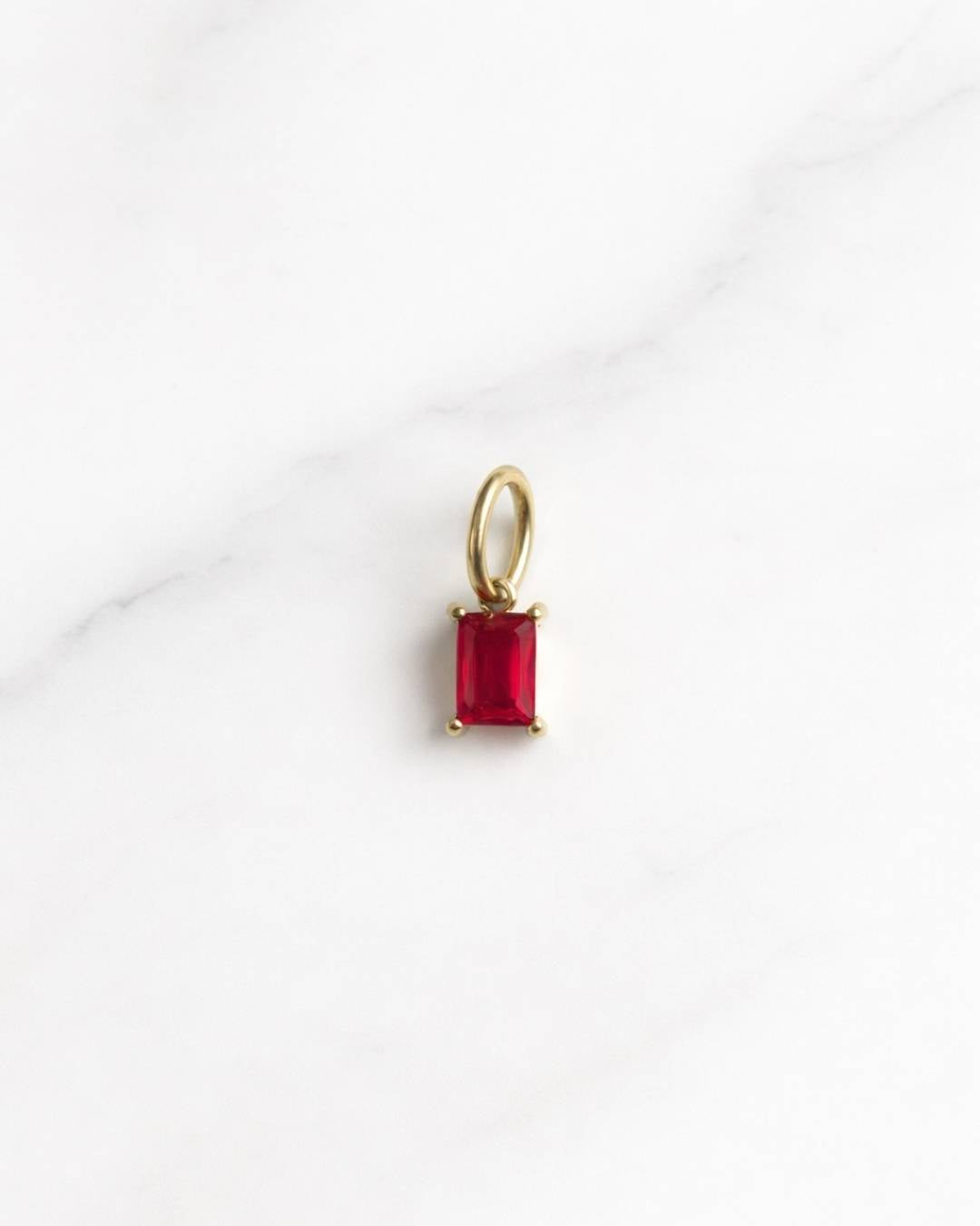 Cairo Charm in Gold mit rotem rechteckigem Stein auf hellem Hintergrund, eleganter Damen-Charm.