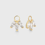 Goldener Charm Lotus mit drei klaren Zirkonia-Steinen als Anhänger für Creolen, frontal fotografiert vor hellem Hintergrund.