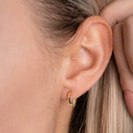 Classic S Creolen in Gold am Ohr getragen – minimalistische Mini-Creole mit Klappverschluss.