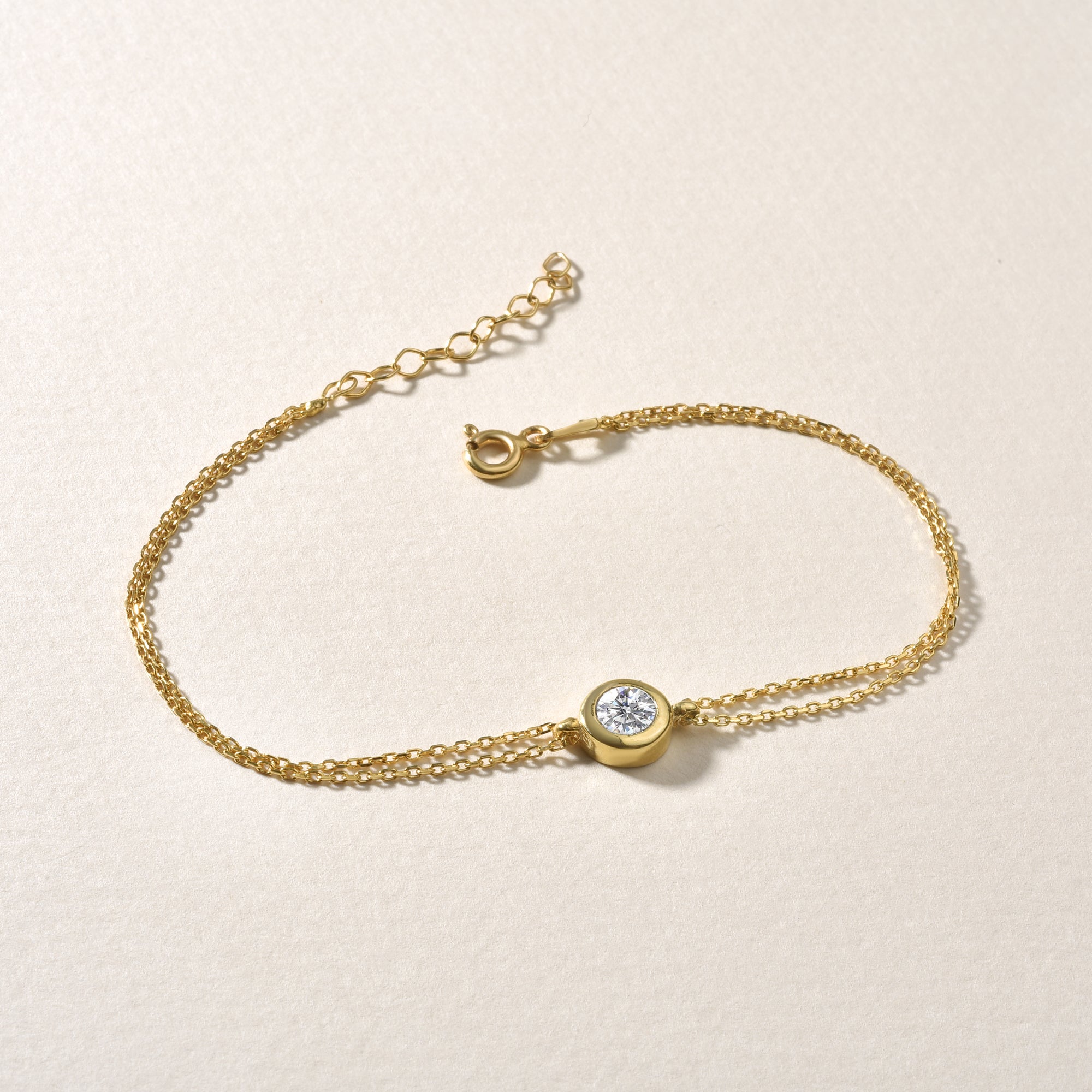 Classy Solitaire Armband Gold flach liegend – Federringverschluss und Verlängerungskette.