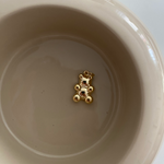 Clear Bear Anhänger Gold aus 925er Silber, liegend in beiger Keramikschale als minimalistisches Stillleben.