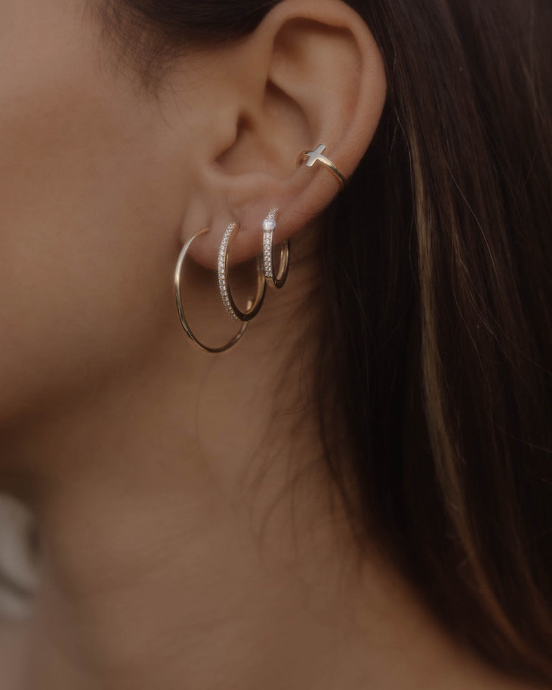 Stacking-Look: Goldene Creolen im Stacking-Look am Ohr – Solitaire Pavé Creole mit Zirkonia kombiniert.