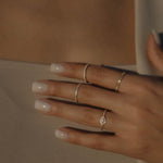 Mehrere filigrane Dkeniz Ringe im Stacking-Look, darunter der Crush Zirkonia Ring in Gold.