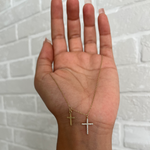 Goldene Double Kreuz Zirkonia Kette mit zwei Anhängern liegend in der Hand.
