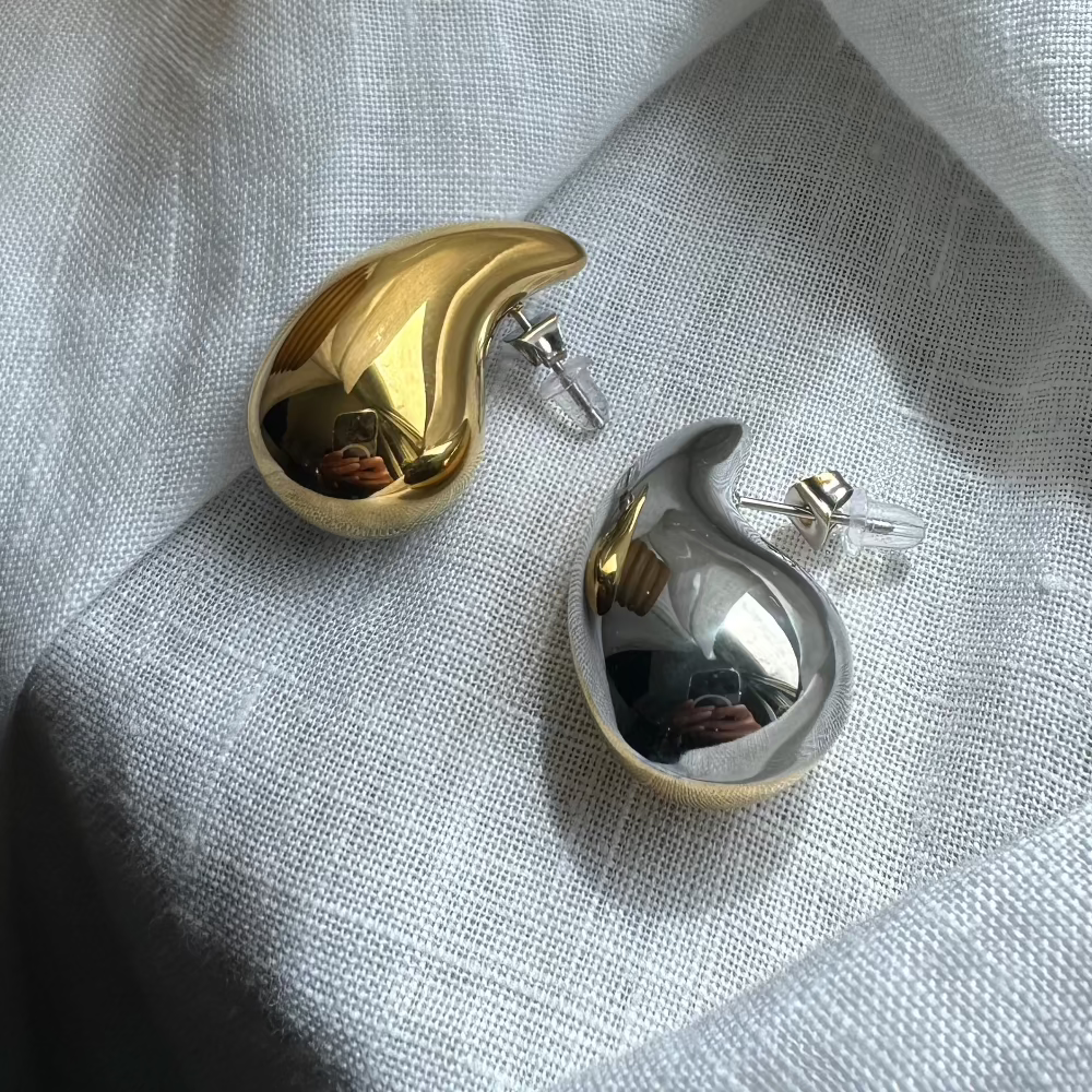 Gold- und silberfarbener Drop Ohrstecker, Rückseite mit Schmetterlingsverschluss, Nahaufnahme.