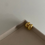 Drop Big Edelstahl Ohrstecker in Gold, glänzende Tropfenform, liegend auf Schmuckbox.