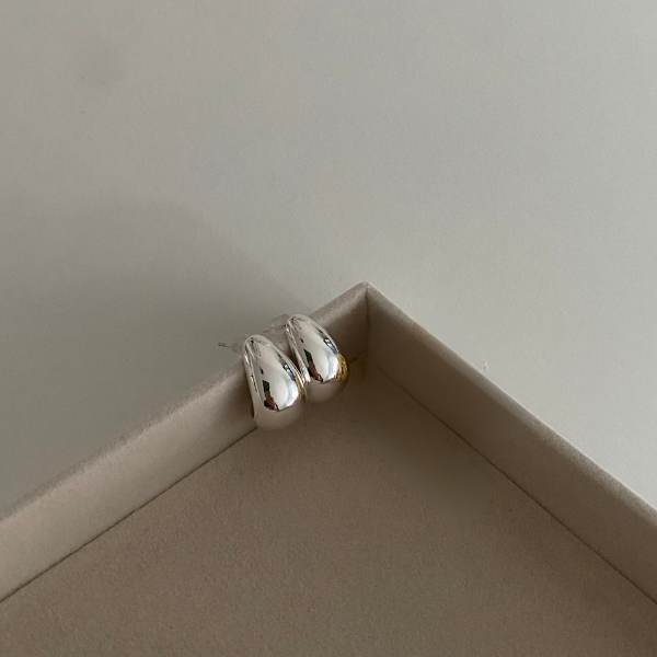 Drop Big Edelstahl Ohrstecker in Silber, glänzende Tropfenform, dekorativ auf Schmuckschachtel.