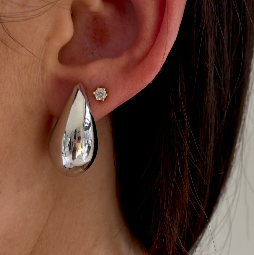 Tragefoto: „Drop Big“ Silber Ohrstecker in Tropfenform am Ohr, glänzend poliert.