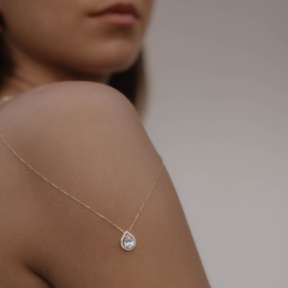 Drops Halskette mit Zirkonia Steinen in Gold an der rechten Schulterseite getragen – zarter Tropfen-Anhänger.