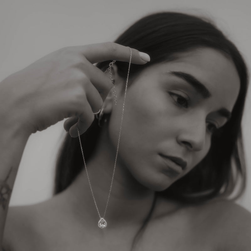 Model hält filigrane Drops Halskette mit Zirkonia in der Hand.