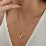 Angel Wings Halskette Gold getragen am Dekolleté – eleganter Engelsflügel Anhänger mit Zirkonia.