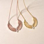Engelsflügel Kette in Gold und Rosé im Vergleich – Angel Wings Anhänger mit Zirkonia auf hellem Untergrund.
