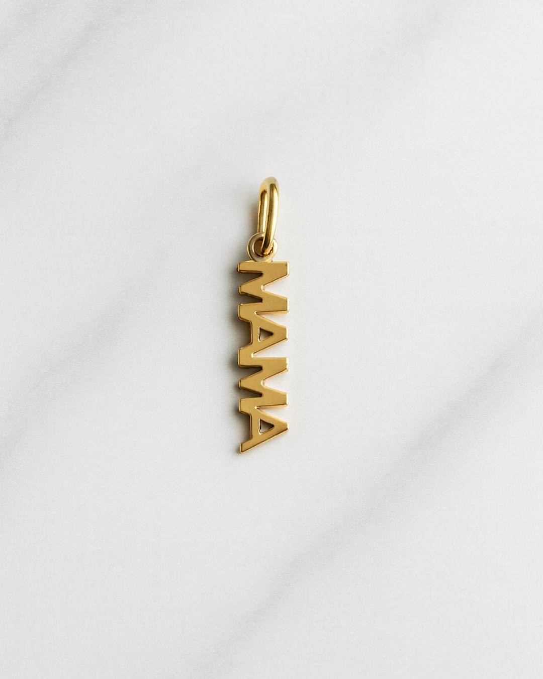 Vergoldeter MAMA Charm der Florenz Kollektion als eleganter Schriftanhänger auf hellem Hintergrund
