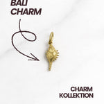 Bali Charm Gold als Produktmotiv mit Schriftzug „Bali Charm“, eleganter muschelartiger Anhänger mittig platziert.