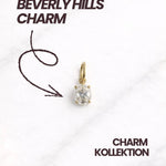 Goldener Beverly Hills CHARM mit funkelndem Stein auf hellem Hintergrund.