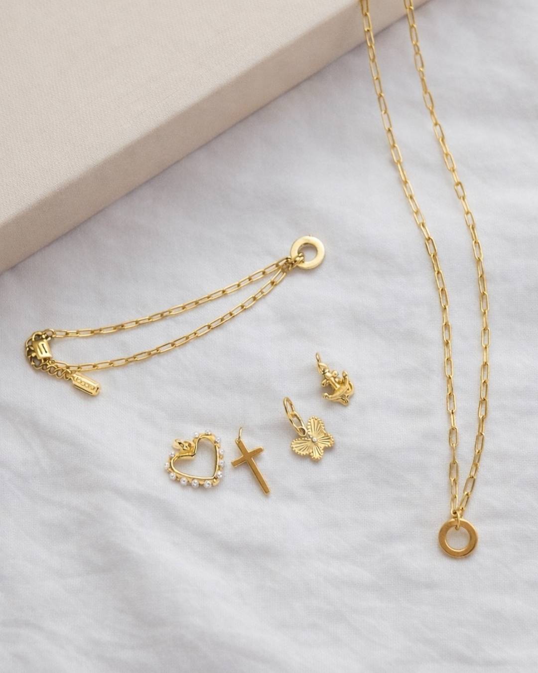 Goldfarbenes Ketten-Set mit Ring-Anhänger, dazu Charms: Herz mit Perlen, Kreuz, Schmetterling und Anker.
