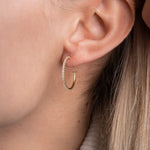 Hoop Earrings Zirkonia Thin M Gold am Ohr getragen, filigrane Creole mit Zirkonia-Besatz.