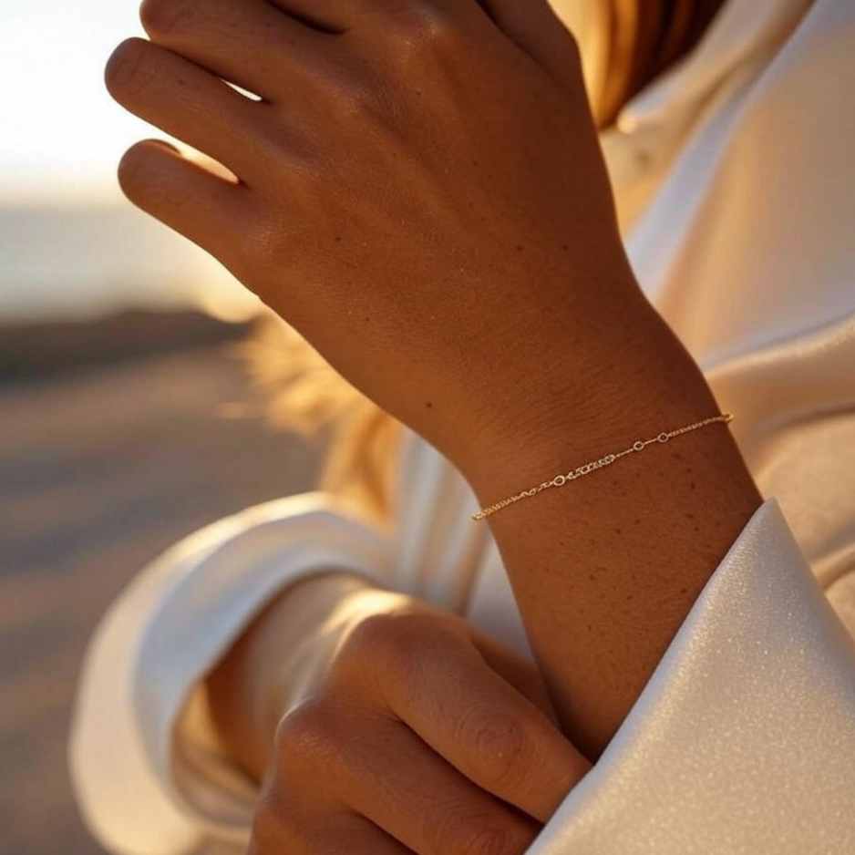 Elegantes Gravurarmband aus goldfarbenem Edelstahl am Handgelenk einer gebräunten Frau im Sonnenlicht. Zeitloses Design, perfekt als Geschenk für Partner, Familie oder zur Selbstbelohnung. Hochwertiges Accessoire mit individueller Gravurmöglichkeit.