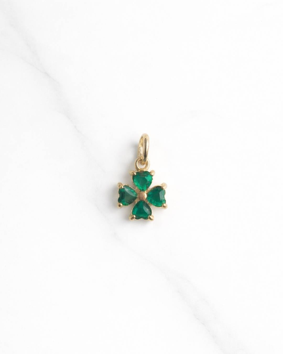 Greenhaven Charm in Gold – grünes Kleeblatt aus herzförmigen Steinen auf hellem Hintergrund.