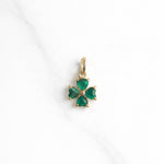 Greenhaven Charm in Gold – grünes Kleeblatt aus herzförmigen Steinen auf hellem Hintergrund.
