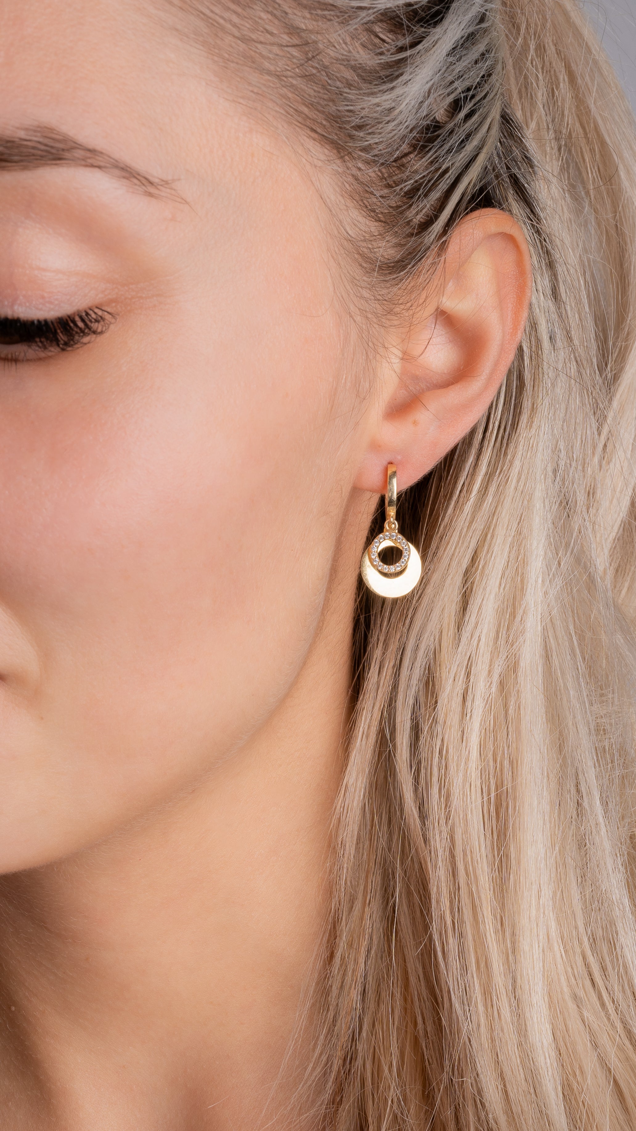 Hängecreolen Halo Zirkonia Rund Gold am Ohr einer Blondine, eleganter Look.