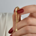 Detailaufnahme Hängecreole Tropfen Gold – Zirkonia-Steine am Ring und Tropfenanhänger an Kette.