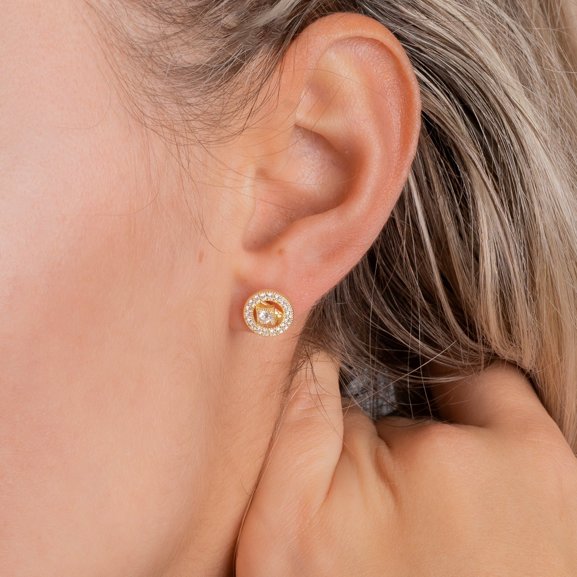 Halou Ohrstecker Gold am Ohr getragen – funkelnder runder Zirkonia-Stecker, eleganter Alltagslook.