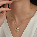 Herz Halskette Gold mit Perlen und Baguette-Zirkonia getragen am Dekolleté.