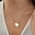 Herz Gravur Halskette Gold getragen – minimalistisches Herz mit funkelndem Zirkonia-Detail.