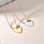 Herz Gravur Halskette Gold neben Silber – eleganter Herzanhänger mit Shiny Closure auf hellem Untergrund gelegt.