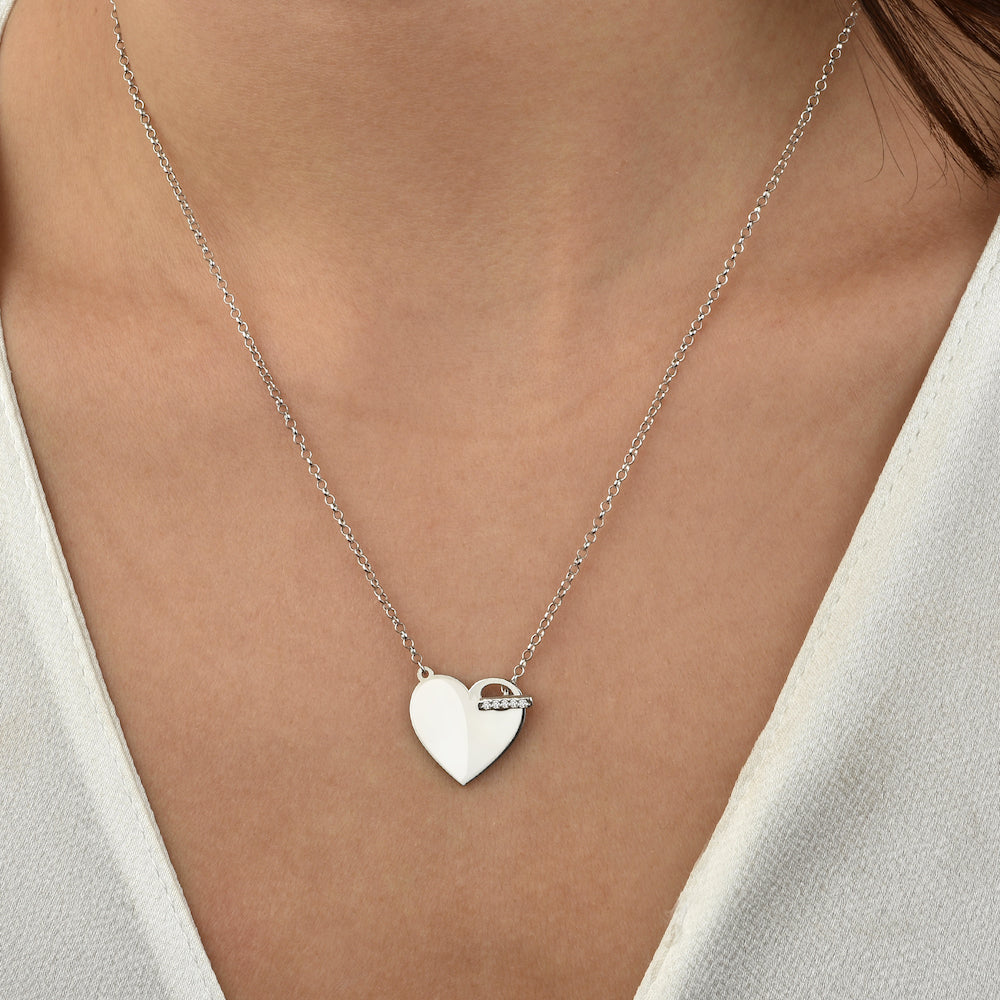 Silberne Herz Gravur Shiny Closure Halskette getragen am Dekolleté einer Frau.