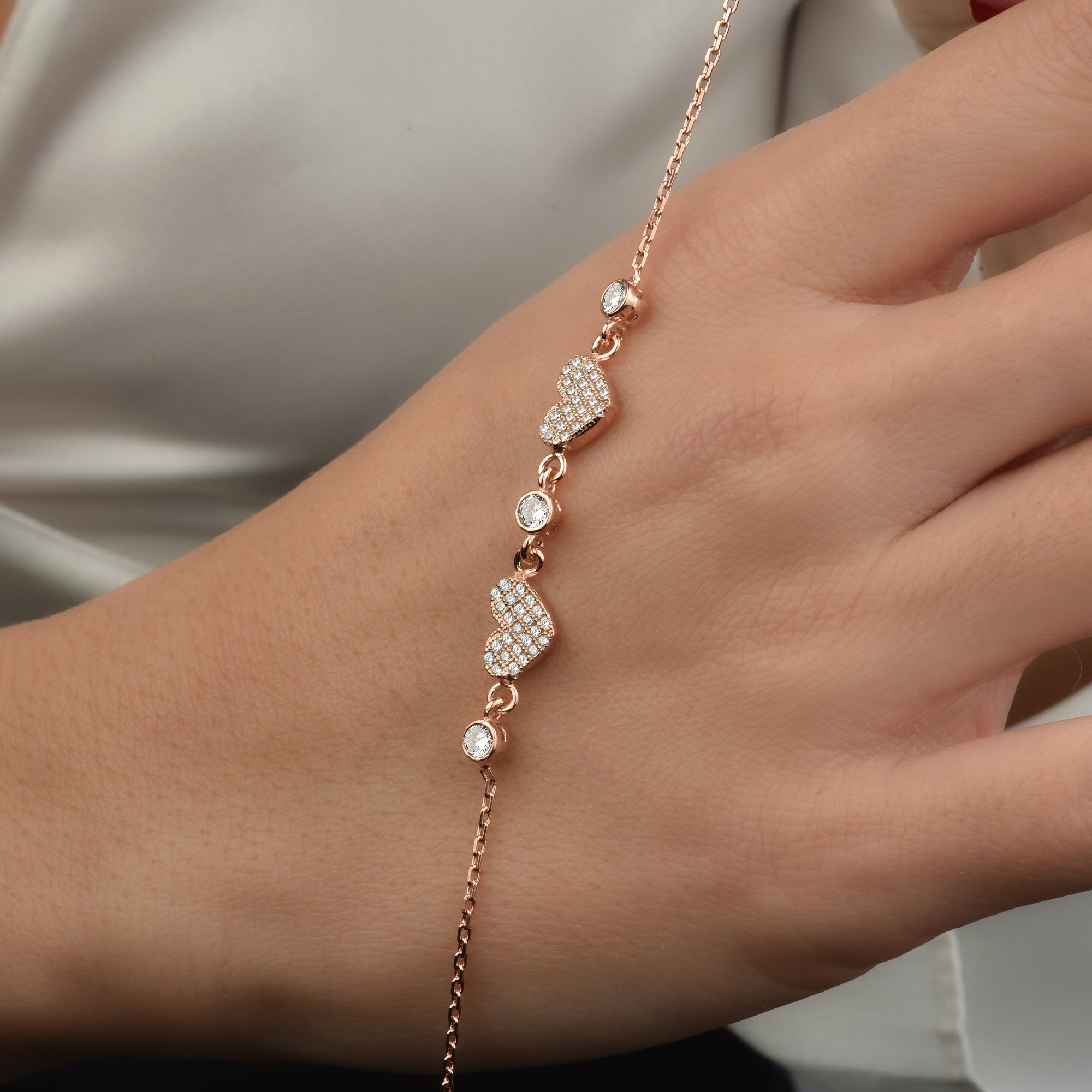 Herz Zirkonia Armkette Rosé, getragen am Handgelenk, eleganter Damenschmuck mit Zirkonia