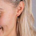 Model trägt Classic Thin M Creolen in Gold – elegante, dünne Hoop Earrings im Alltag.