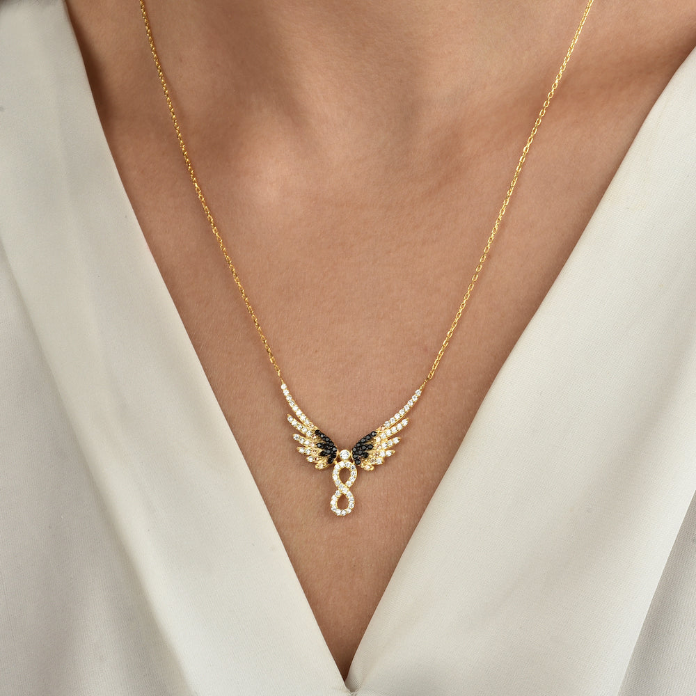 Goldene Infinity Angel Wings Halskette mit Flügeln und Unendlichkeitszeichen am Hals getragen.