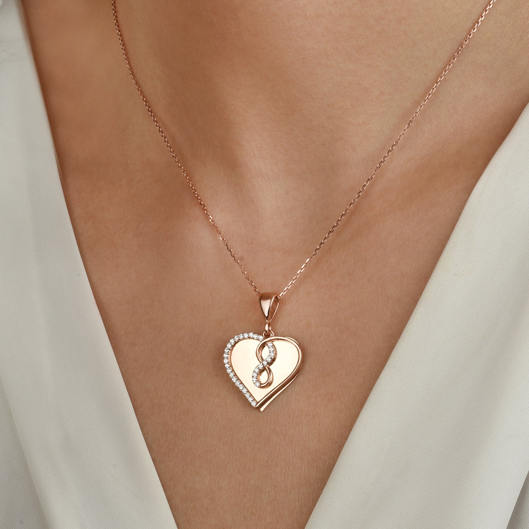 Infinity Love Kette Rosé vergoldet, Herzanhänger mit Zirkonia Steinen, getragen am Dekolleté