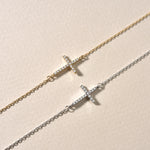 Vergleich: Kreuz Armkette mit Zirkonia in Gold und Silber auf hellem Hintergrund.