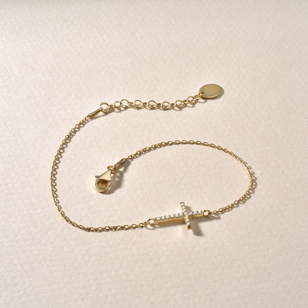 Kreuz Armkette Gold mit Zirkonia – Detailaufnahme auf hellem Hintergrund.