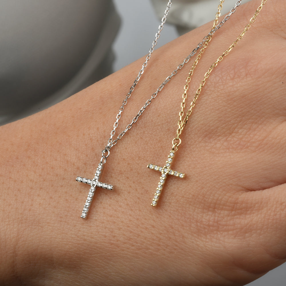 Silberne und goldene Kreuz Zirkonia Ketten auf einer Hand als Vergleich.