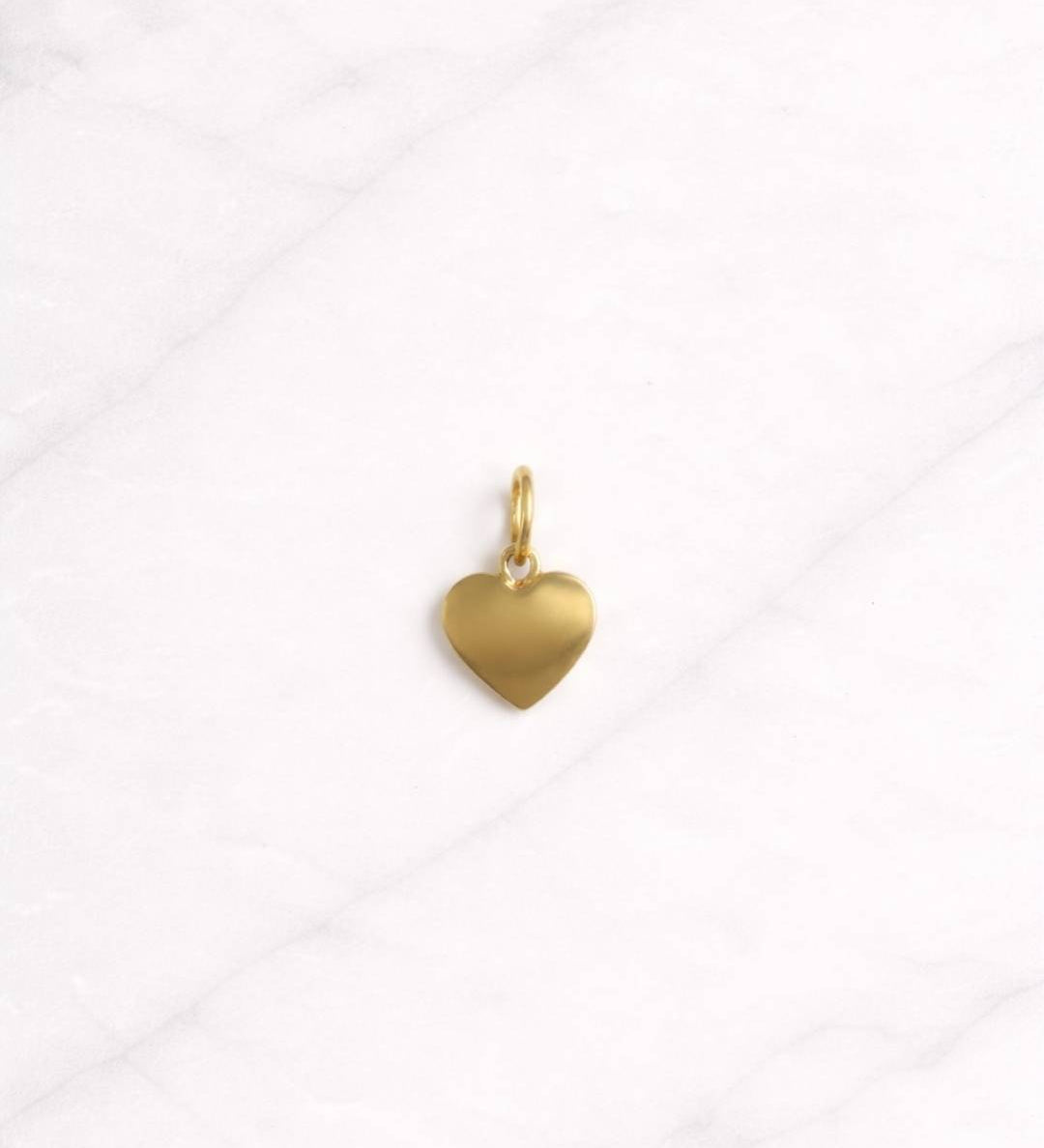 Kyoto CHARM als goldener Herz Anhänger auf hellem Hintergrund, minimalistisch und elegant.