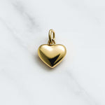 Vergoldeter Herz Charm der Lissabon Kollektion auf hellem Marmorfond, ideal für Mix und Match Ketten
