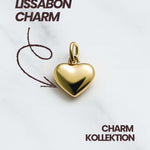 Vergoldeter Herz Charm der Lissabon Kollektion auf hellem Marmorfond, ideal für Mix und Match Ketten